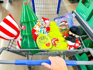 hand pushing a Walmart cart with Dollar Spot Holiday decorations in the front