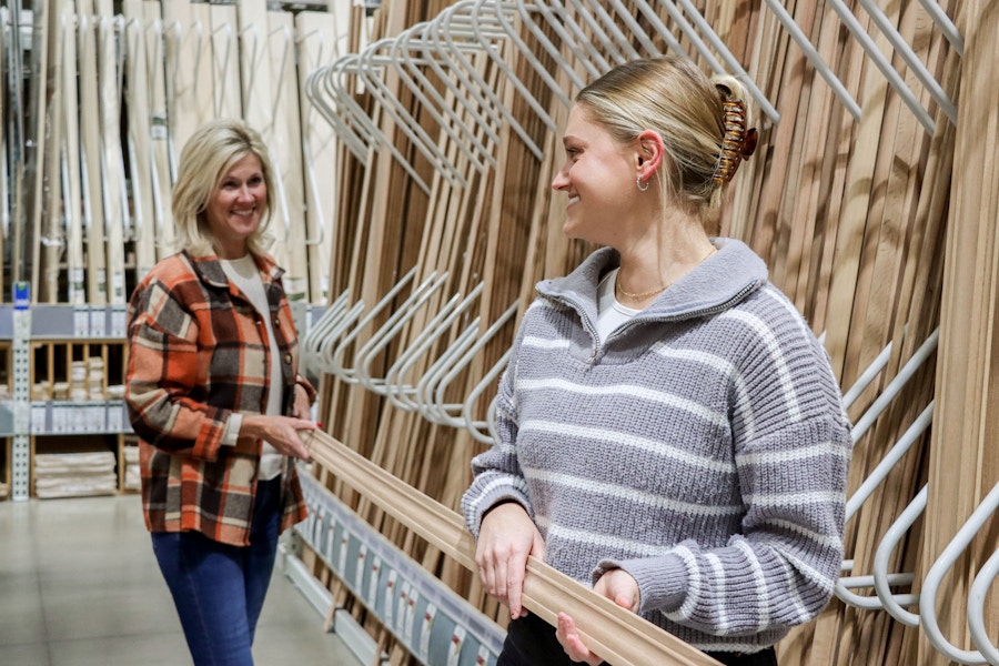 two people carrying wood at menards