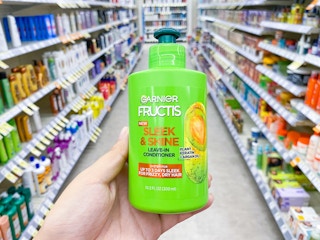 hand holding garnier fructis leave in conditioner walgreens