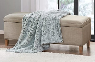 a throw blanket on an ottoman