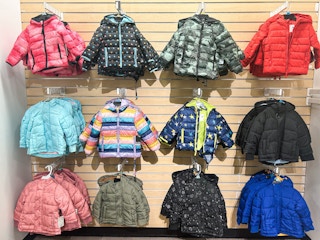 kids puffer jackets displayed on a wall