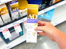 hand holding an a+d overnight healing ointment in front of a target shelf