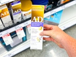 hand holding an a+d overnight healing ointment in front of a target shelf