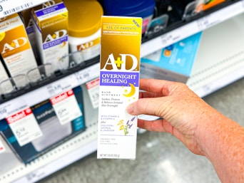 hand holding an a+d overnight healing ointment in front of a target shelf
