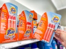 hand grabbing a tide stain pen 3-pack off a target shelf