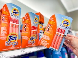 hand grabbing a tide stain pen 3-pack off a target shelf