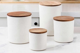 lifestyle image of a 4-piece ceramic kitchen canister set with acacia wood lids