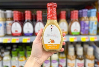 hand holding bottle of skinnygirl salad dressing in front of other skinnygirl dressings on shelves taken with portrait mode
