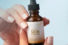 Person holding a vitamin c serum in their hands.