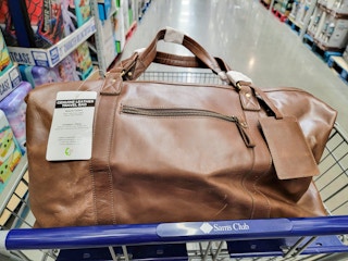 brown leather duffle bag in a cart