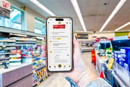 hand holding a smartphone in a store with kcl app and 1-clip coupon