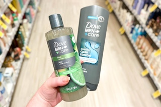 hand holding two Dove Men+Care body washes in a store aisle