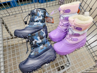 2 pairs of kids snow boots in a cart