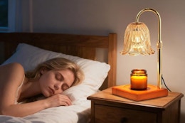 a woman sleeping next to a candle warmer lamp