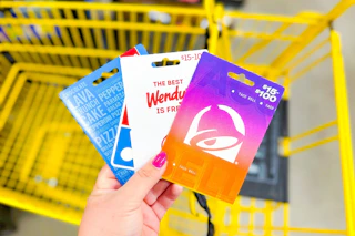 hand holding domino's, wendy's, taco bell gift cards