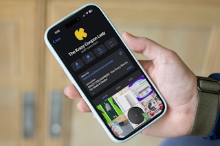 someone holding a phone showing the kcl telegram channel page