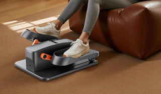 a person sitting in a chair using a mini elliptical machine