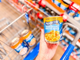 A can of Progresso soup held up over Walmart shopping cart