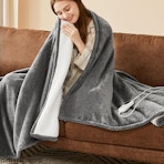 a person sitting on a couch wrapped in a blanket