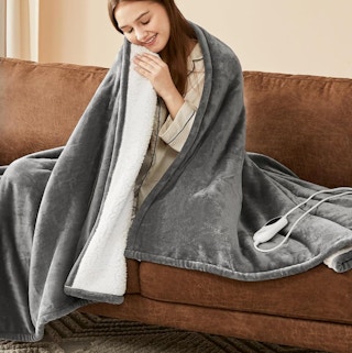 a person sitting on a couch wrapped in a blanket