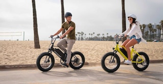 best ebike for the money - couple riding e-bikes alongside beach