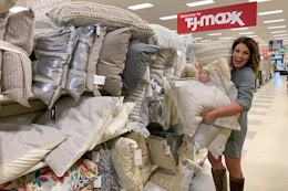 A woman holding a bunch of pillows.