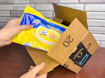 Someone pulling some Lysol wipes out of an Amazon box
