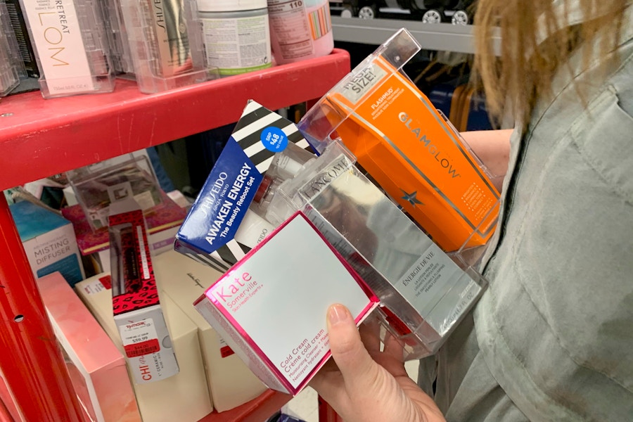 Woman holds a pile of beauty products in her hands