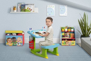 lifestyle image of a child drawing at a cocomelon desk