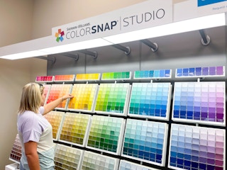 woman looking at a large wall of paint colors and swatches at Sherwin-Williams