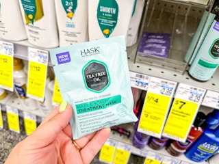person holding a hask hair mask by the shelf