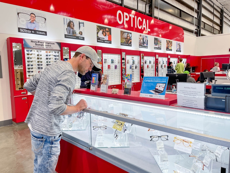 a man looking at costco optical eyeglasses in case