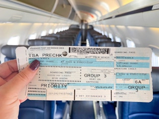 woman holding airplane ticket on plane