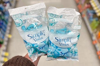 hand holding two bags of simply venus razors in store aisle