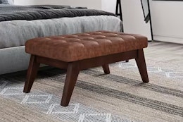 Lifestyle image of the Distressed Saddle Brown of the Simpli Home Ottoman in home setting