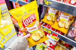 hand holding up a bag of lay's potato chips