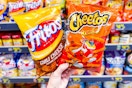 hand holding bags of fritos and cheetos