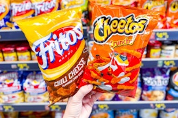 hand holding bags of fritos and cheetos