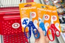 hand holding 3 fiskars scissors in front of a target cart