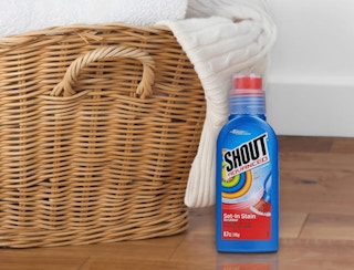 a blue bottle of Shout next to a basket of laundry