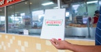 Dozens box of donuts being held by a model inside a krispy kreme store