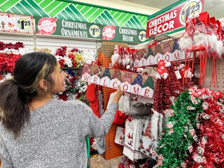 a woman shopping christmas decor in the dollar tree 