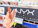 hand holding two nyx professional makeup products