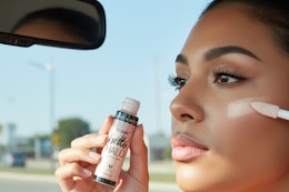 a woman applying wet n wild highlighter