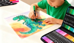a kid coloring a picture with a marker set