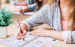 a person writing in a planner at a desk