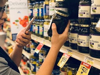 woman scans pickle jar w phone