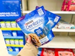 hand holding 2 purina dentalife dog treats at target