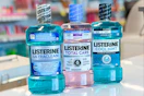 three bottles of Listerine mouthwash on a store counter