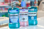 three bottles of Listerine mouthwash on a store counter